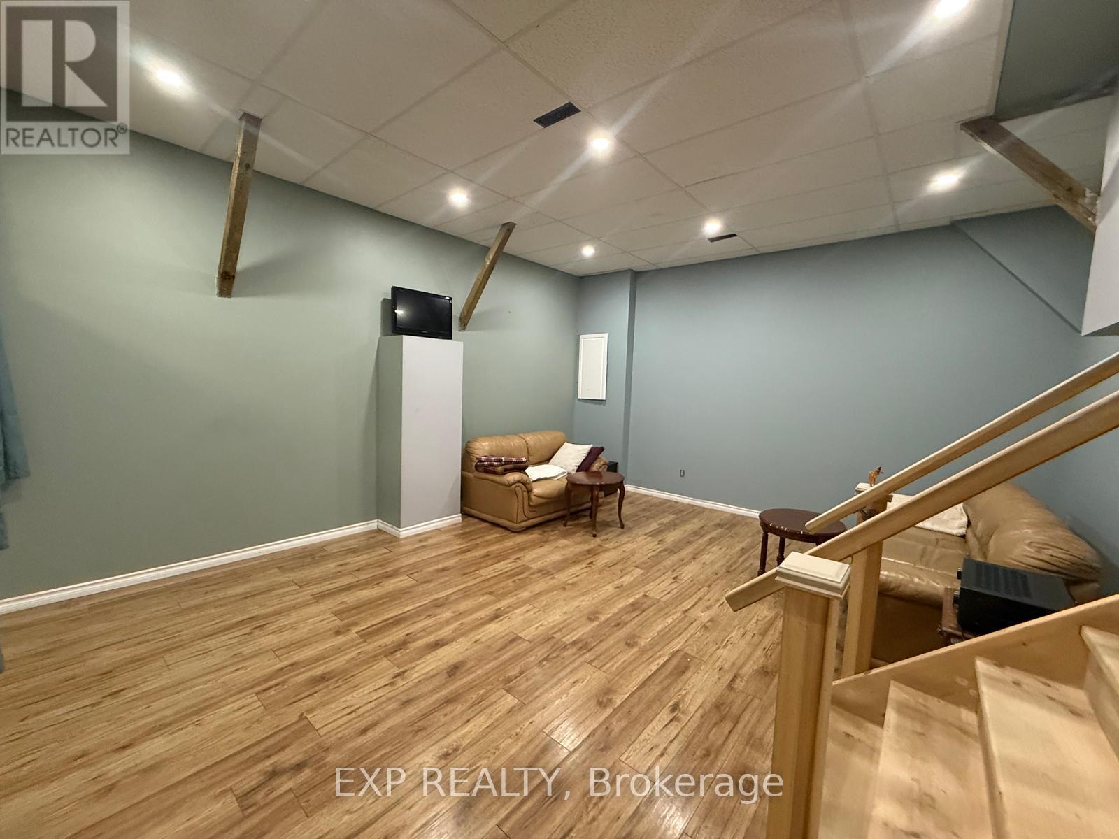 A room with wooden flooring and a staircase.