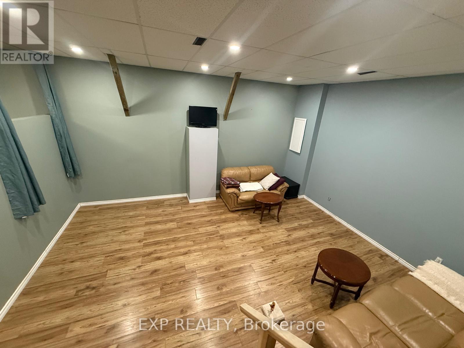 A room with wooden flooring and a couch.