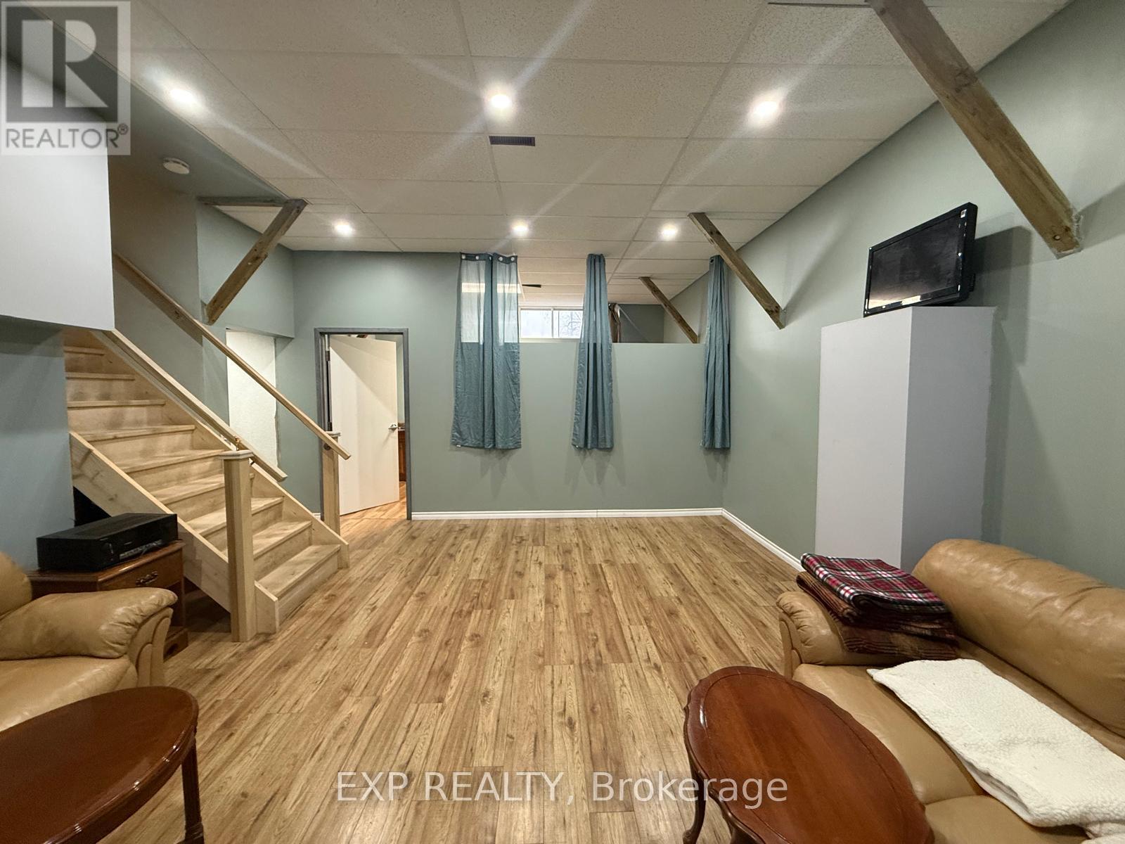 A living room with wooden floors and a staircase.