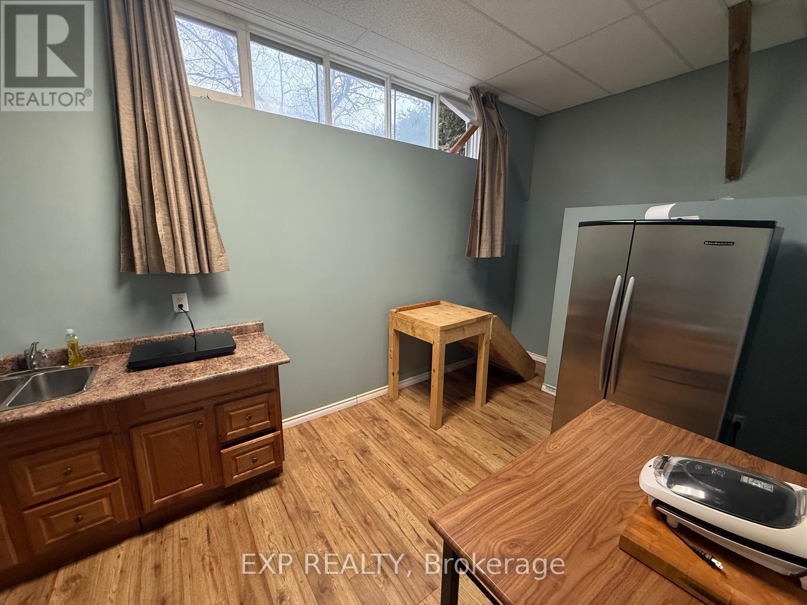 A kitchen with wooden floors and a wooden table with a toaster on it.