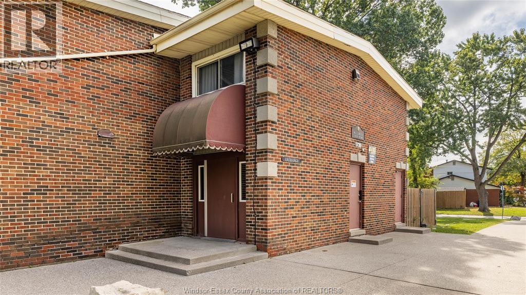 A red brick building with a brown door and a small porch.