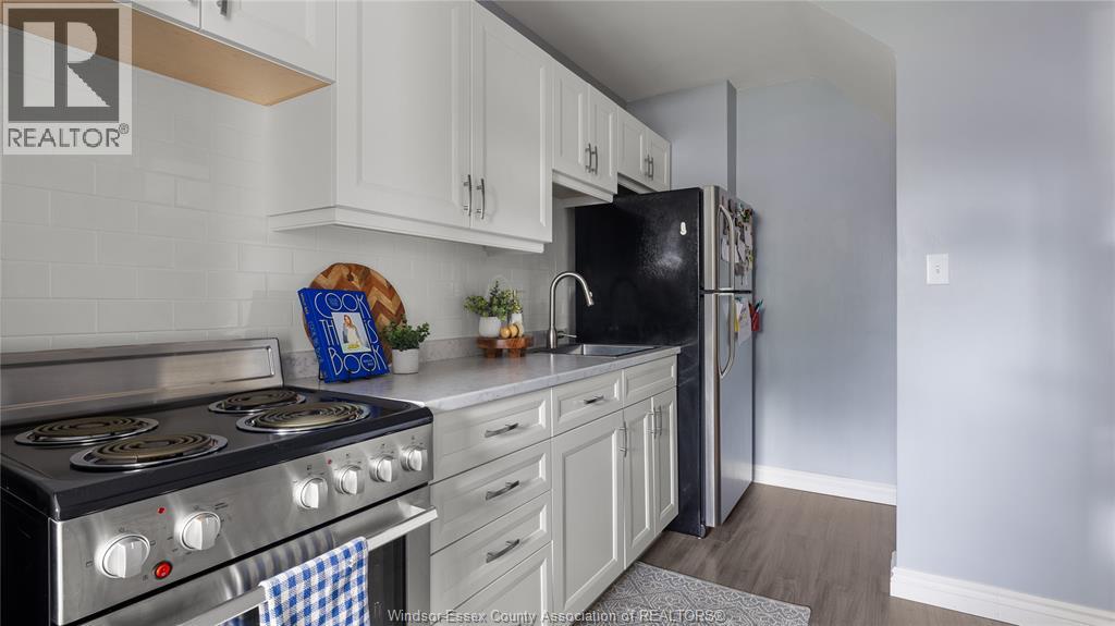 A kitchen with a stove top oven and a refrigerator.