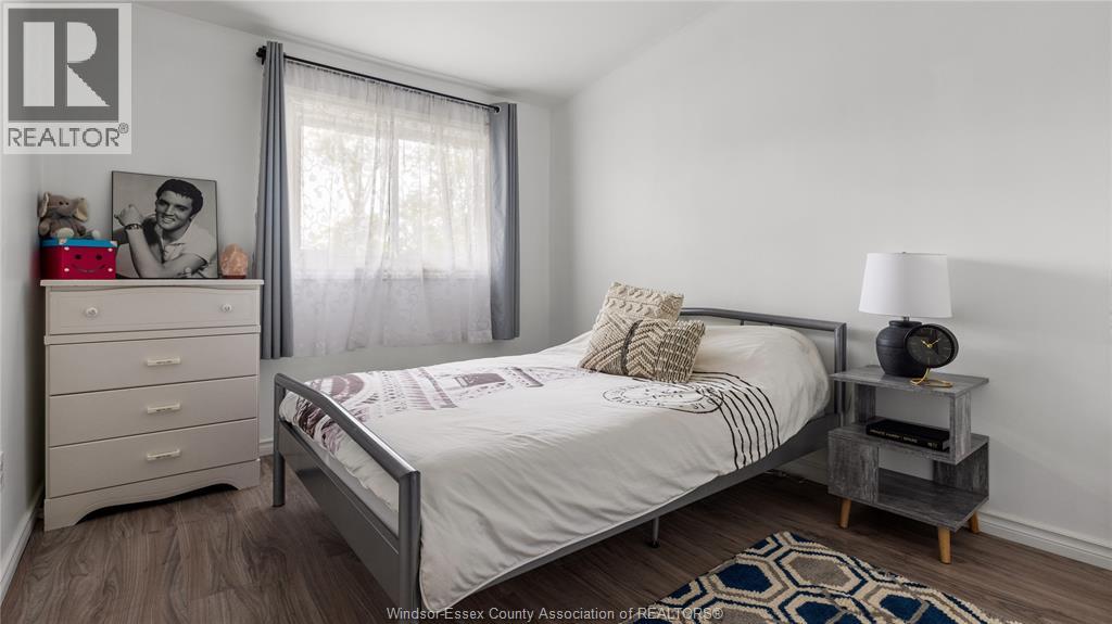 A bedroom with a bed, nightstand, and a dresser.