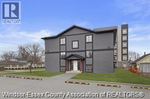 A grey building with the logo REALTOR on the top left corner.