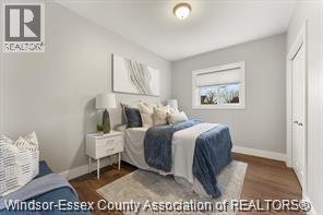A bedroom with a bed, nightstand, and lamp.
