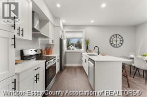 A kitchen with white cabinets and a clock on the wall.