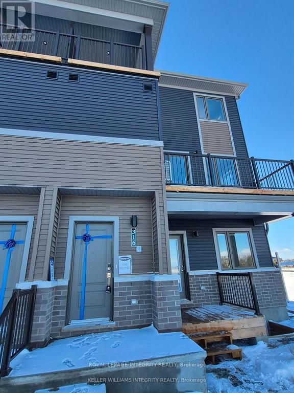 A house with a grey and brown exterior is shown with a blue tape on the door.