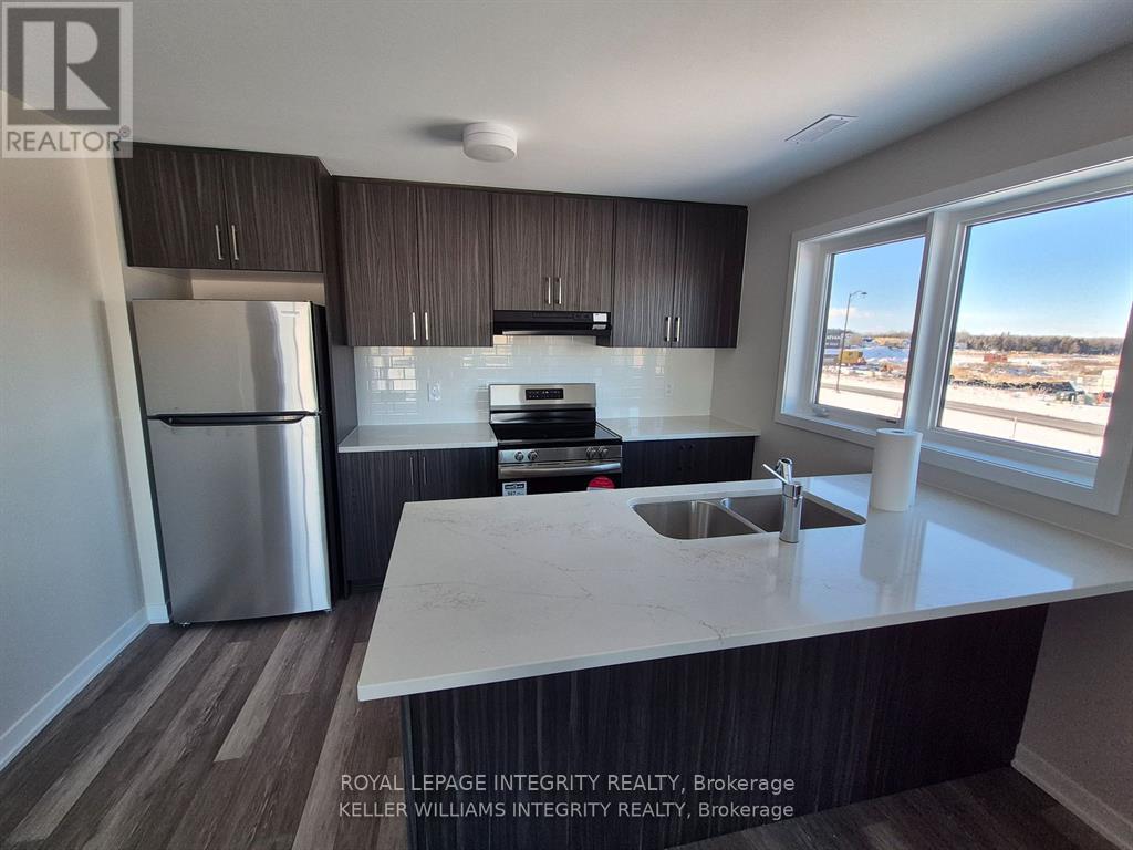 A kitchen with a white counter top and a stainless steel refrigerator.