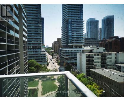 A view of a city from a balcony with buildings and a road.