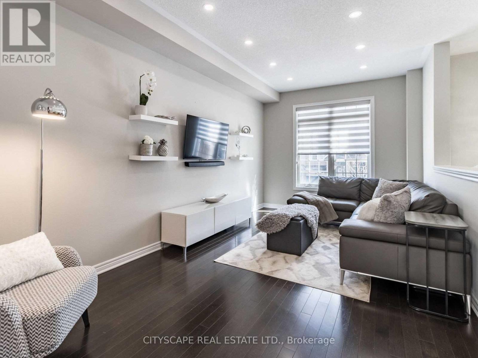 A living room with a grey couch and a white chair.