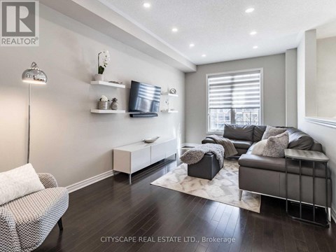 A living room with a grey couch and a white chair.