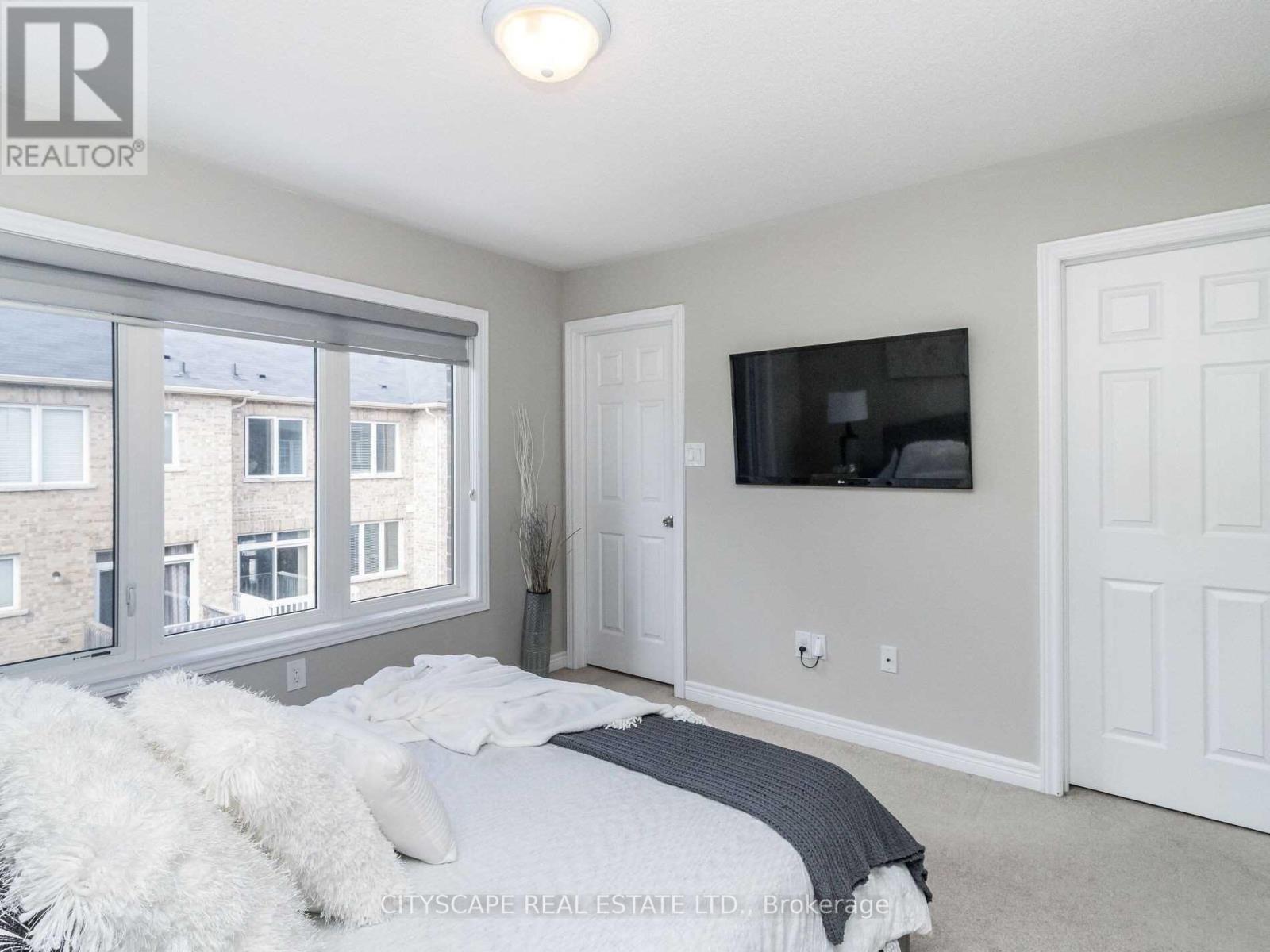 A bedroom with a large bed and a flat screen TV mounted on the wall.