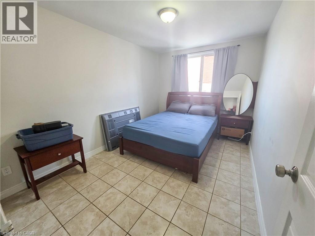 A bedroom with a bed, nightstand, and a table with a container on it.