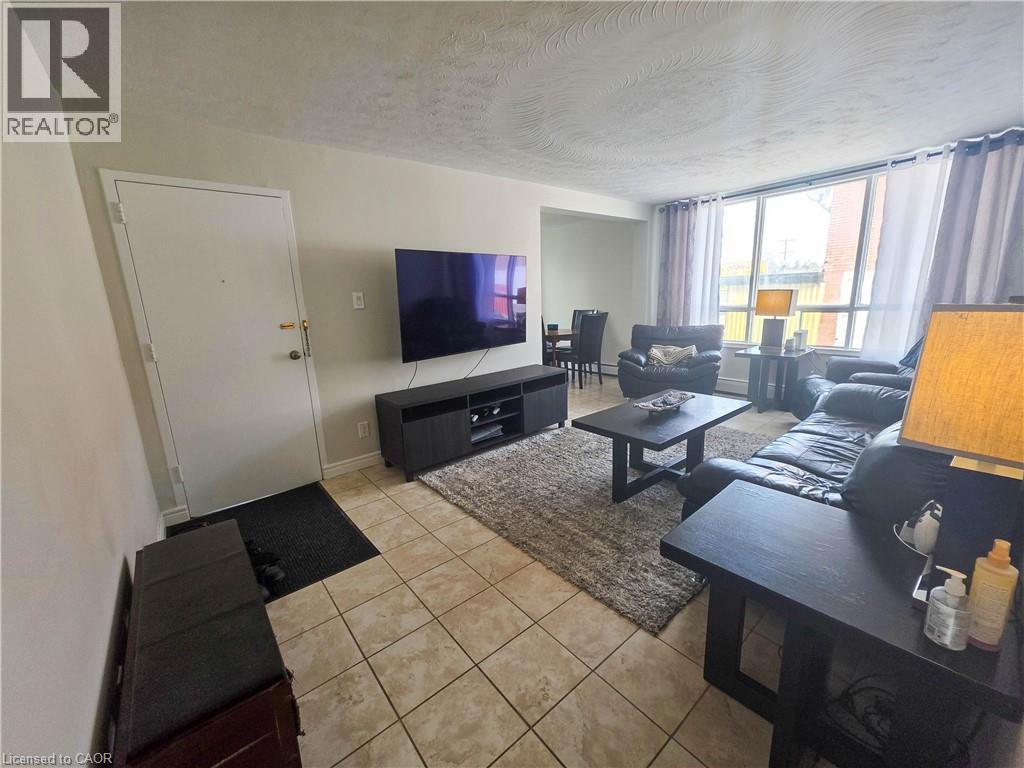 A living room with a flat screen TV and a black sofa.