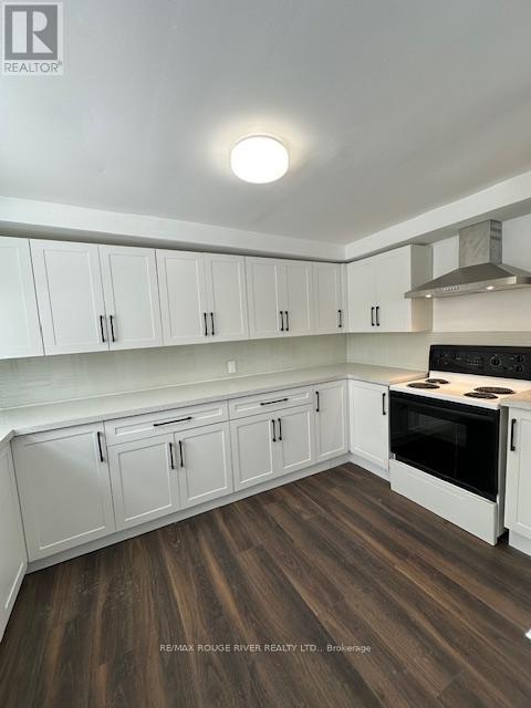 A kitchen with white cabinets and a wooden floor.