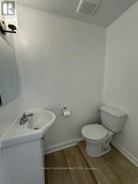 A white toilet and sink in a small bathroom.