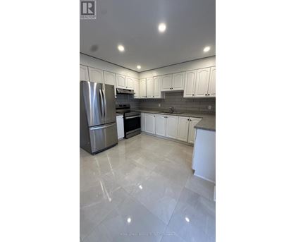 A modern kitchen with white cabinets and a marble floor.