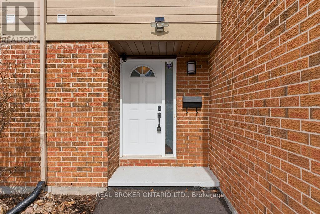A white door is on the brick wall of a building.