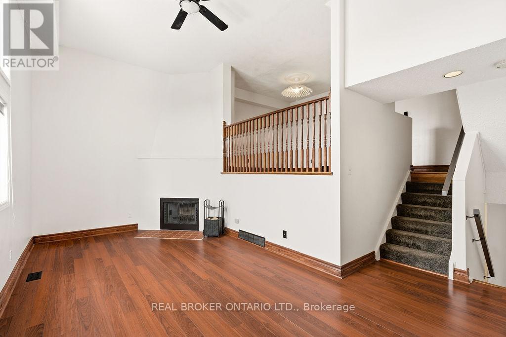 A living room with wood floors and a staircase.