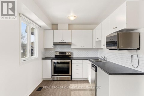 A modern kitchen with white cabinets and stainless steel appliances.