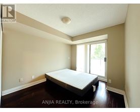 A bedroom with a bed, wooden floors, and a window.