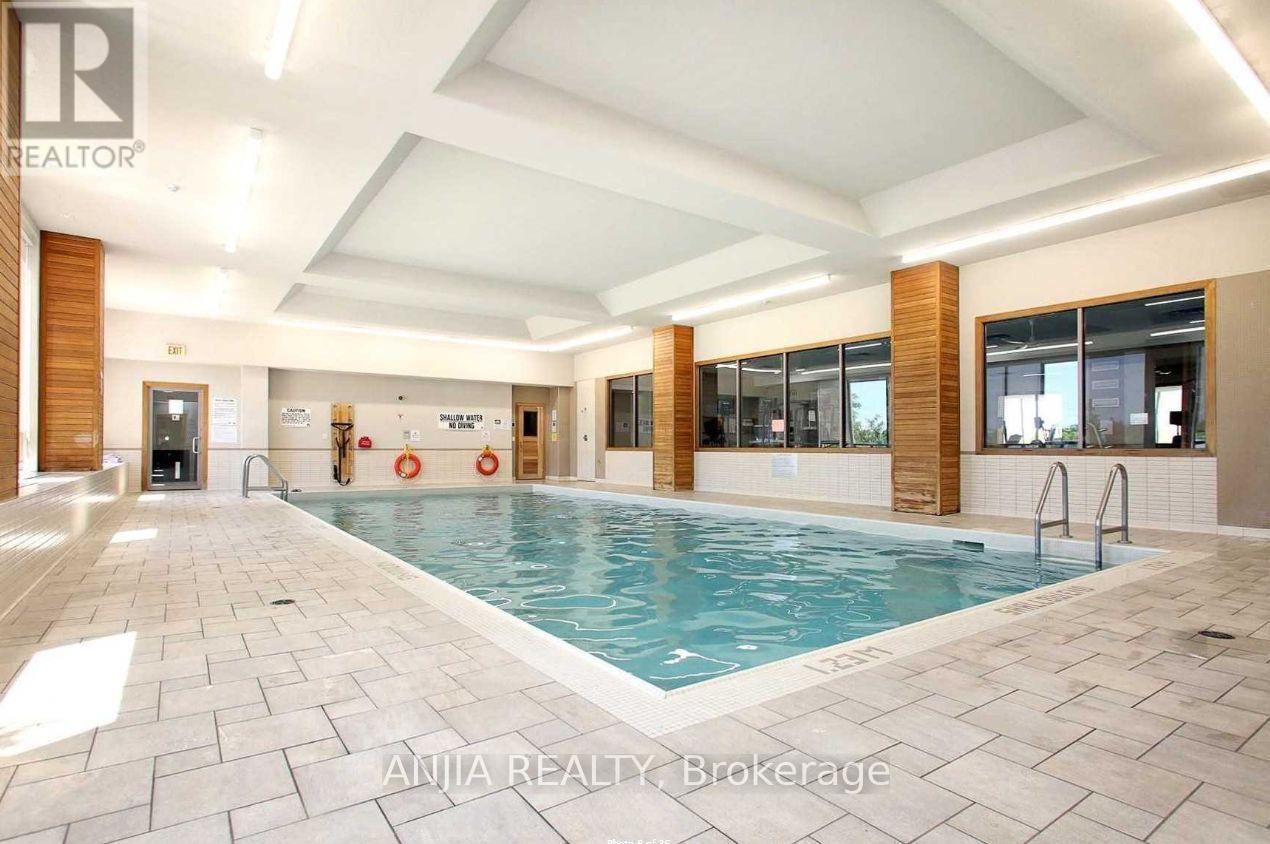 A large indoor swimming pool with a tiled floor and a glass wall on one side.