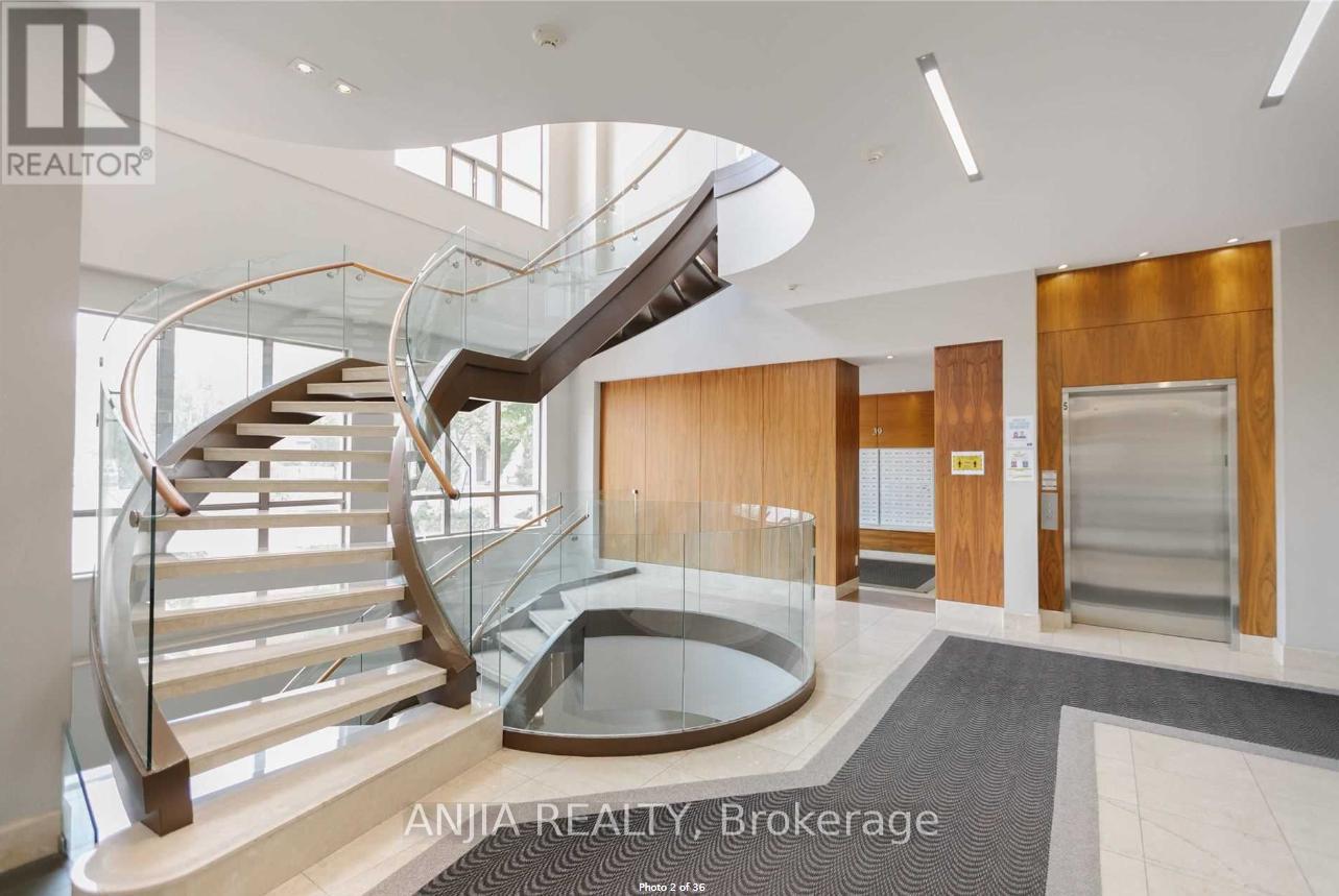 A modern interior space with a curved staircase and glass railings.