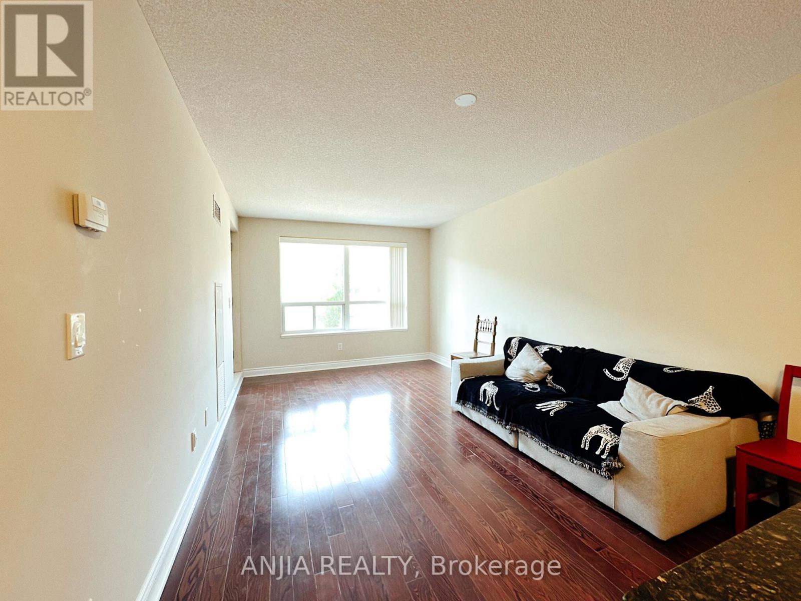 A living room with a couch and a window.