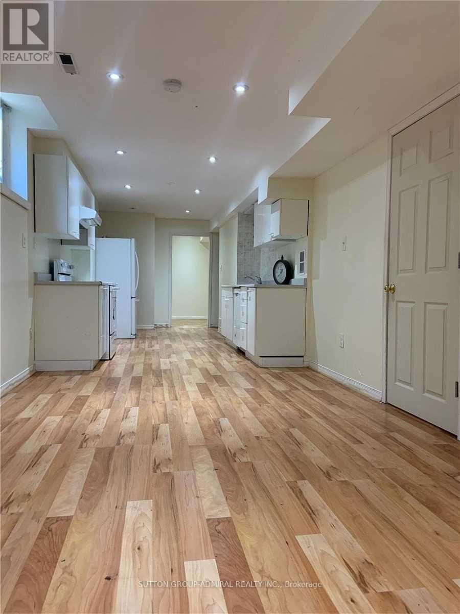 A long hallway with wood floors and white walls.