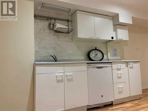 A kitchen with white cabinets and a clock on the counter.