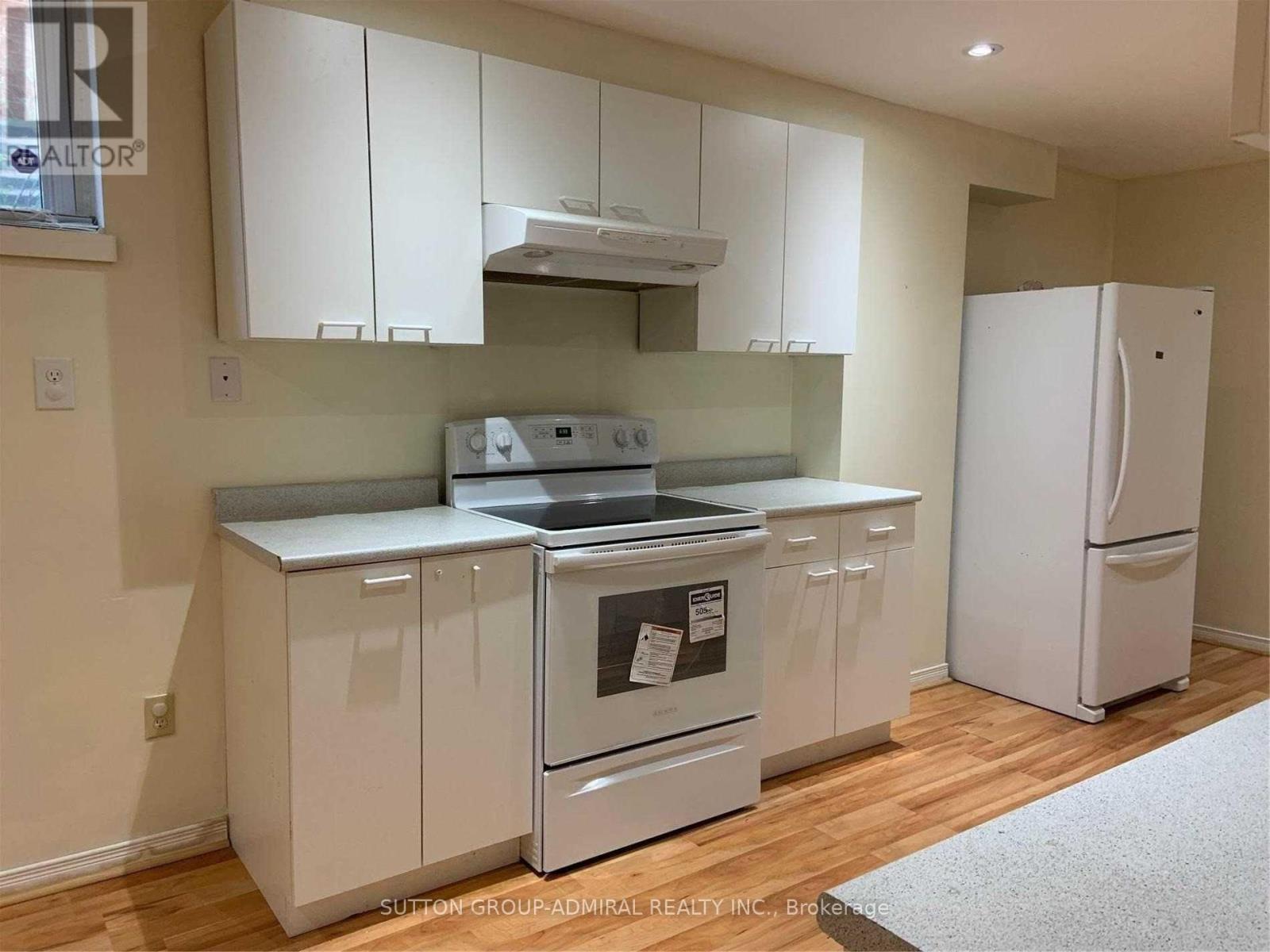 A kitchen with white appliances and cabinets.