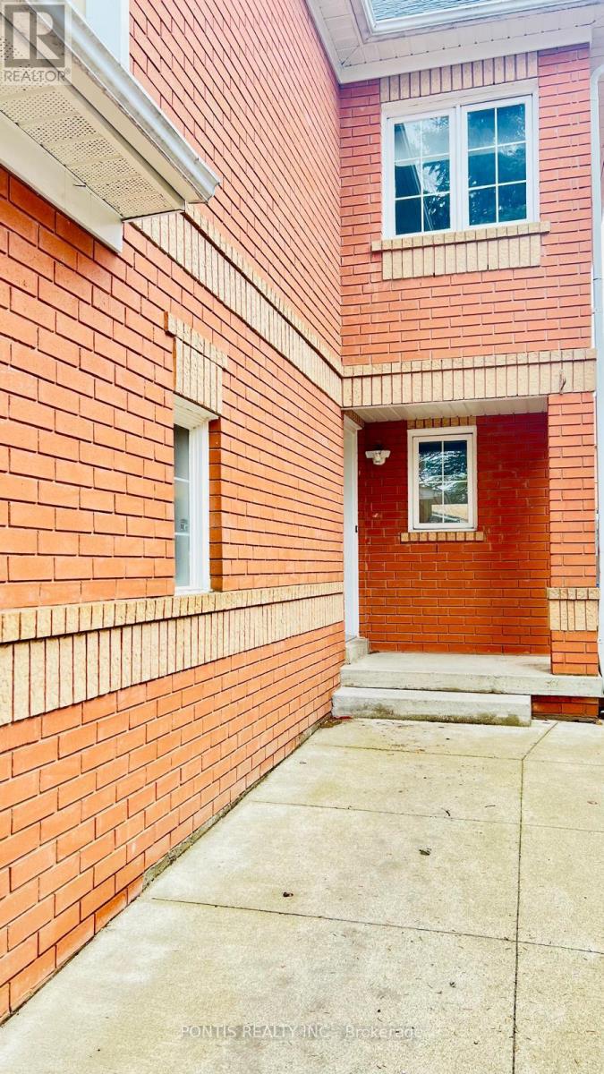 A red brick building with a white window and a door.