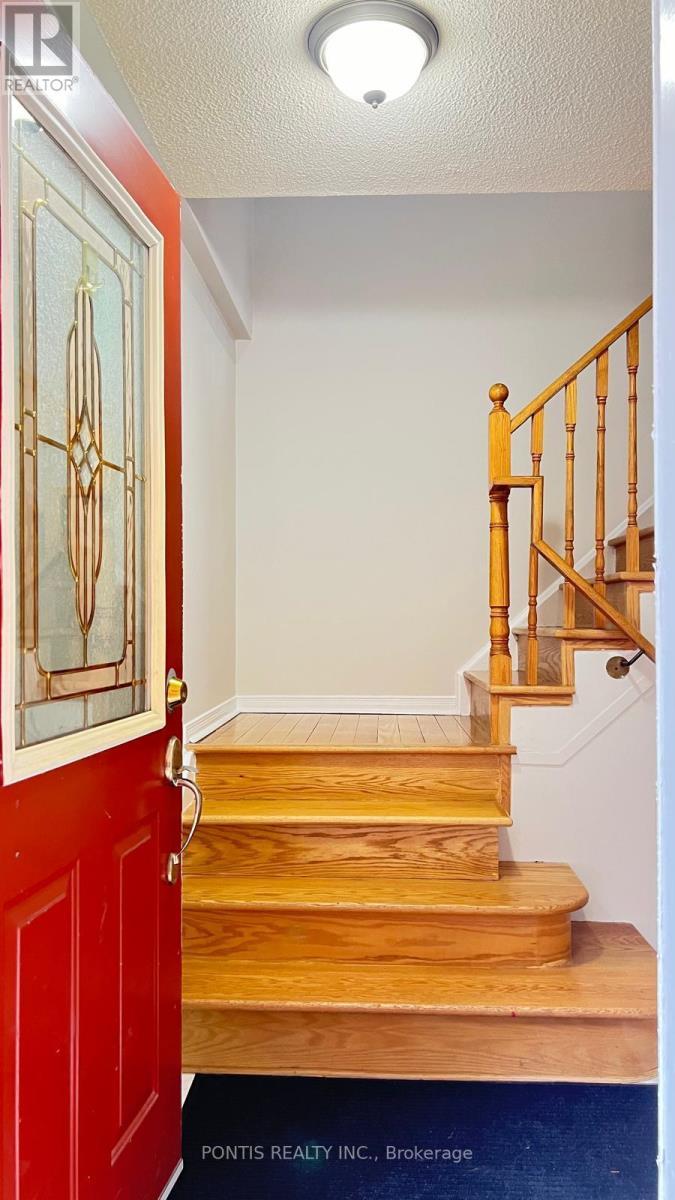 A red door with a glass window and a wooden staircase.