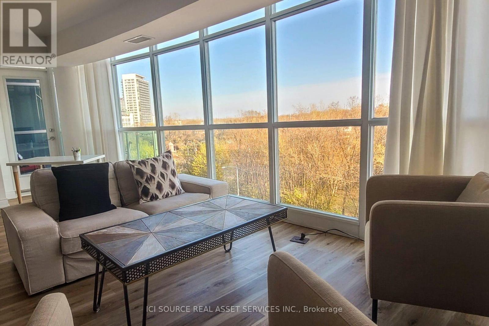 A living room with a large window overlooking a field.