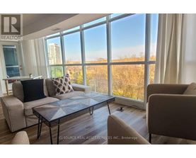 A living room with a large window overlooking a field.
