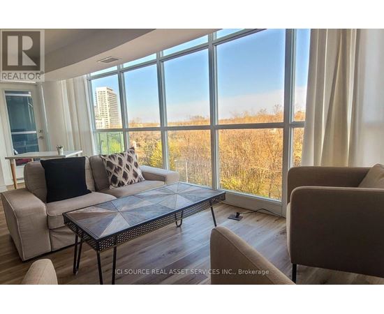 A living room with a large window overlooking a field.