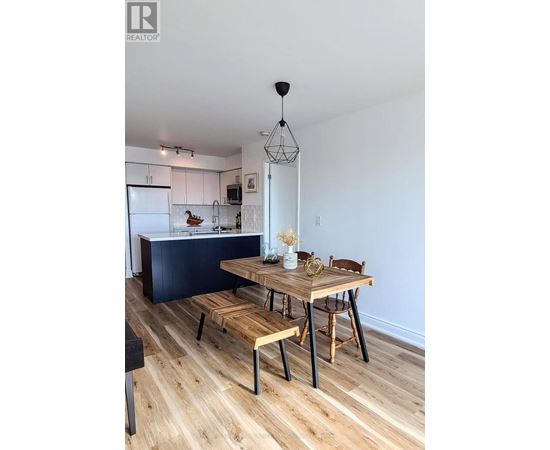 A modern kitchen with a wooden table and chairs.