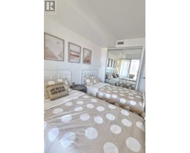A bedroom with two beds and a mirror.