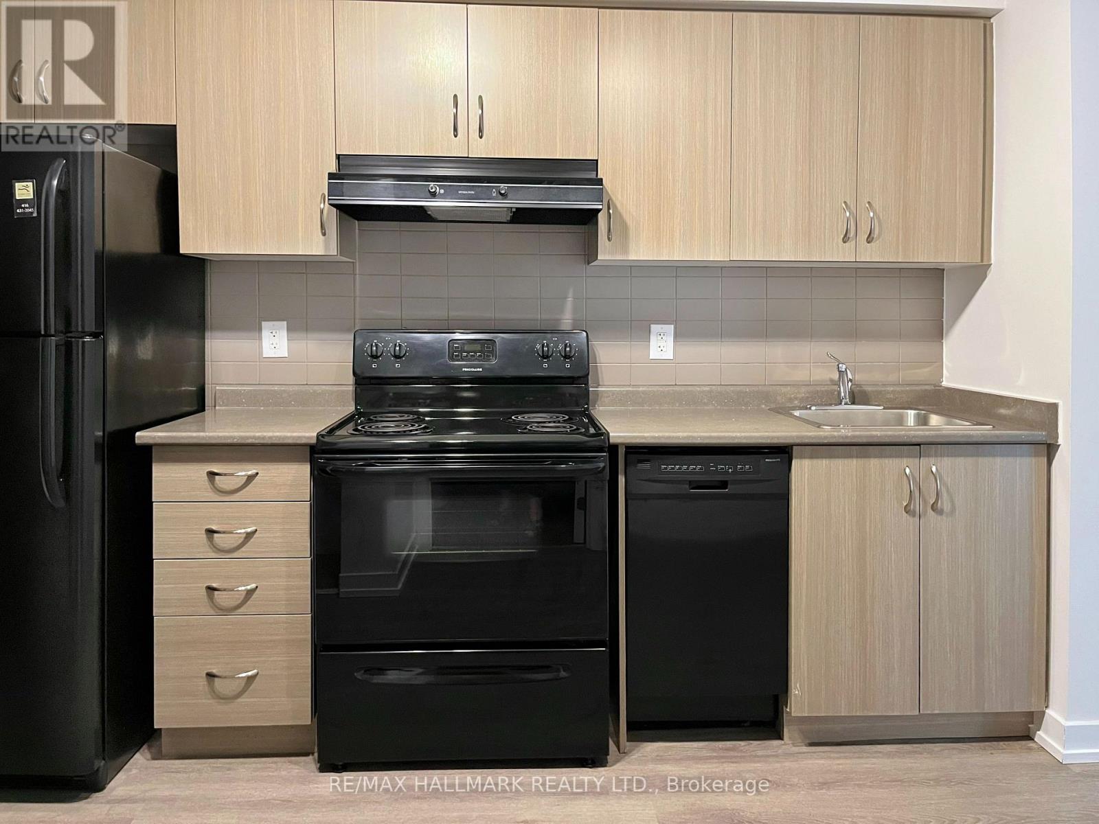 A kitchen with black appliances and wooden cabinets.
