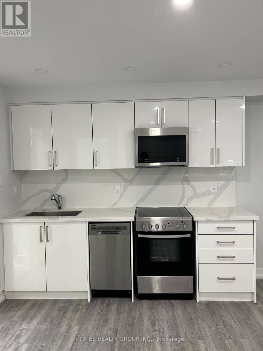 A kitchen with white cabinets and a black microwave.