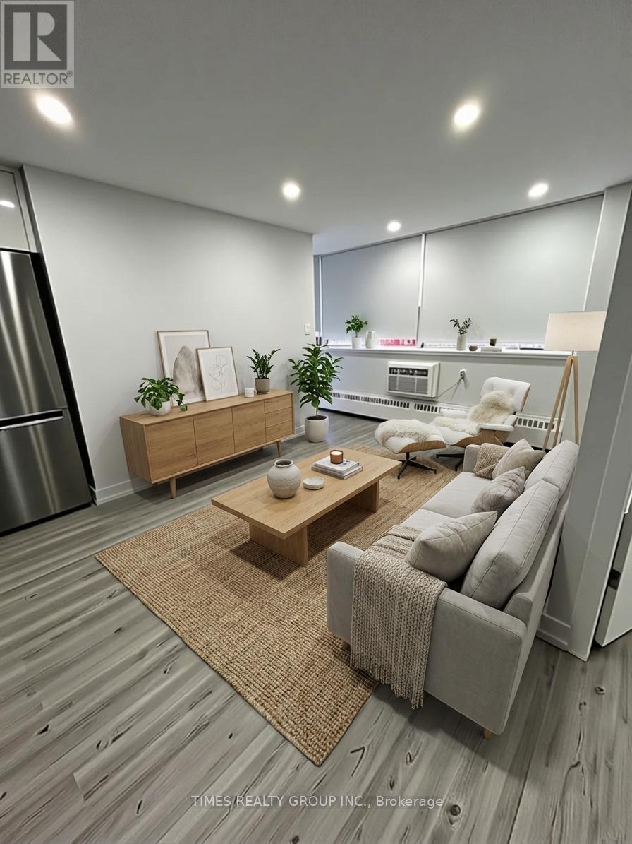 A modern living room with a grey sofa, wooden coffee table, and a large mirror on the wall.