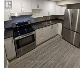 A modern kitchen with stainless steel appliances and white cabinets.