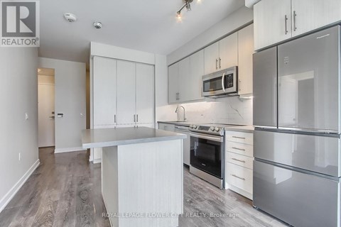 A kitchen with white cabinets and stainless steel appliances.