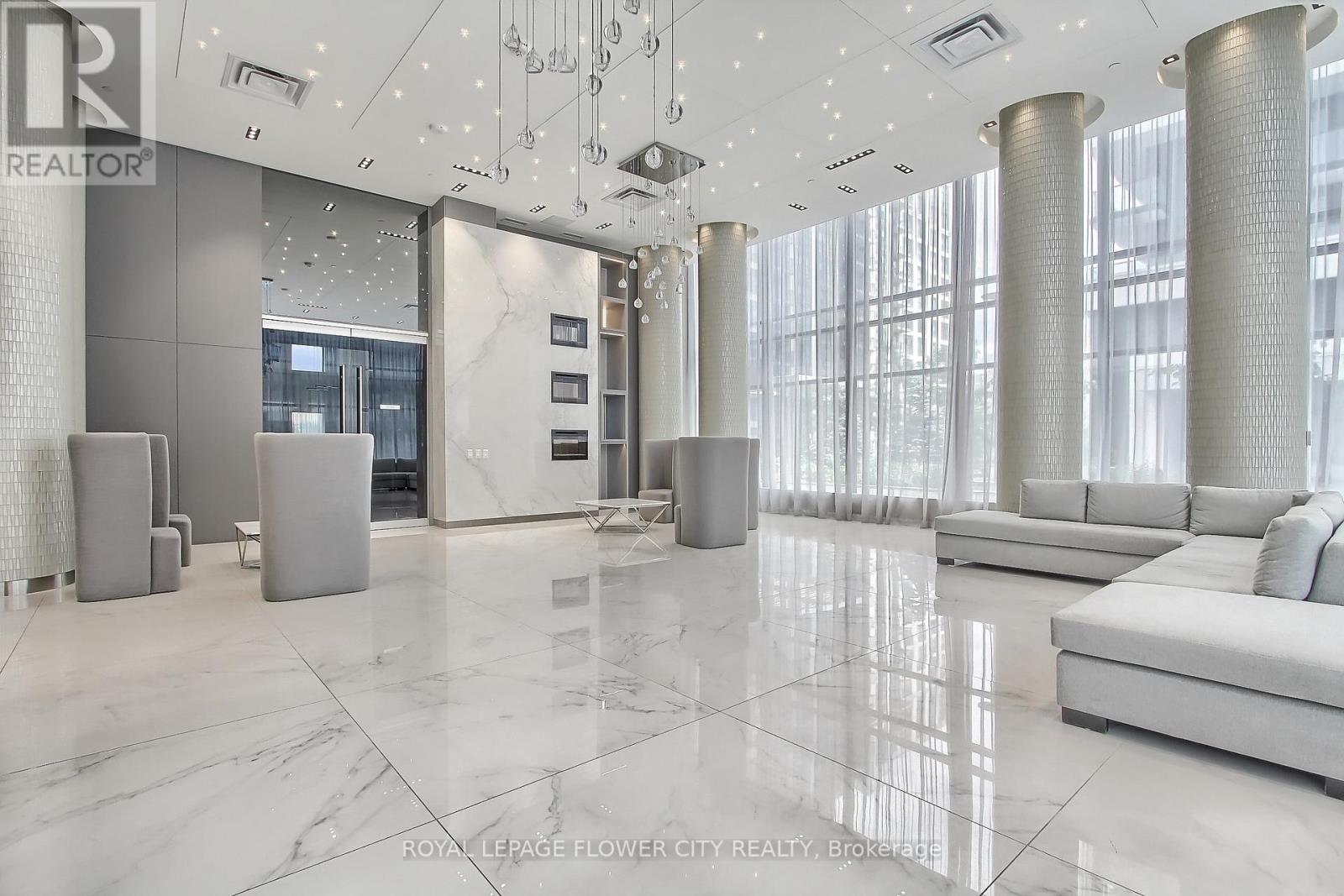 A spacious lobby with marble floors and a reception desk.