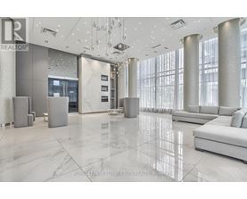 A spacious lobby with marble floors and a reception desk.