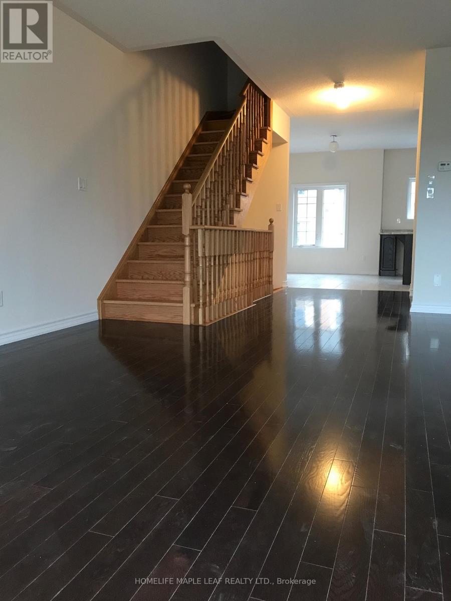 A spacious room with a wooden staircase and black flooring.