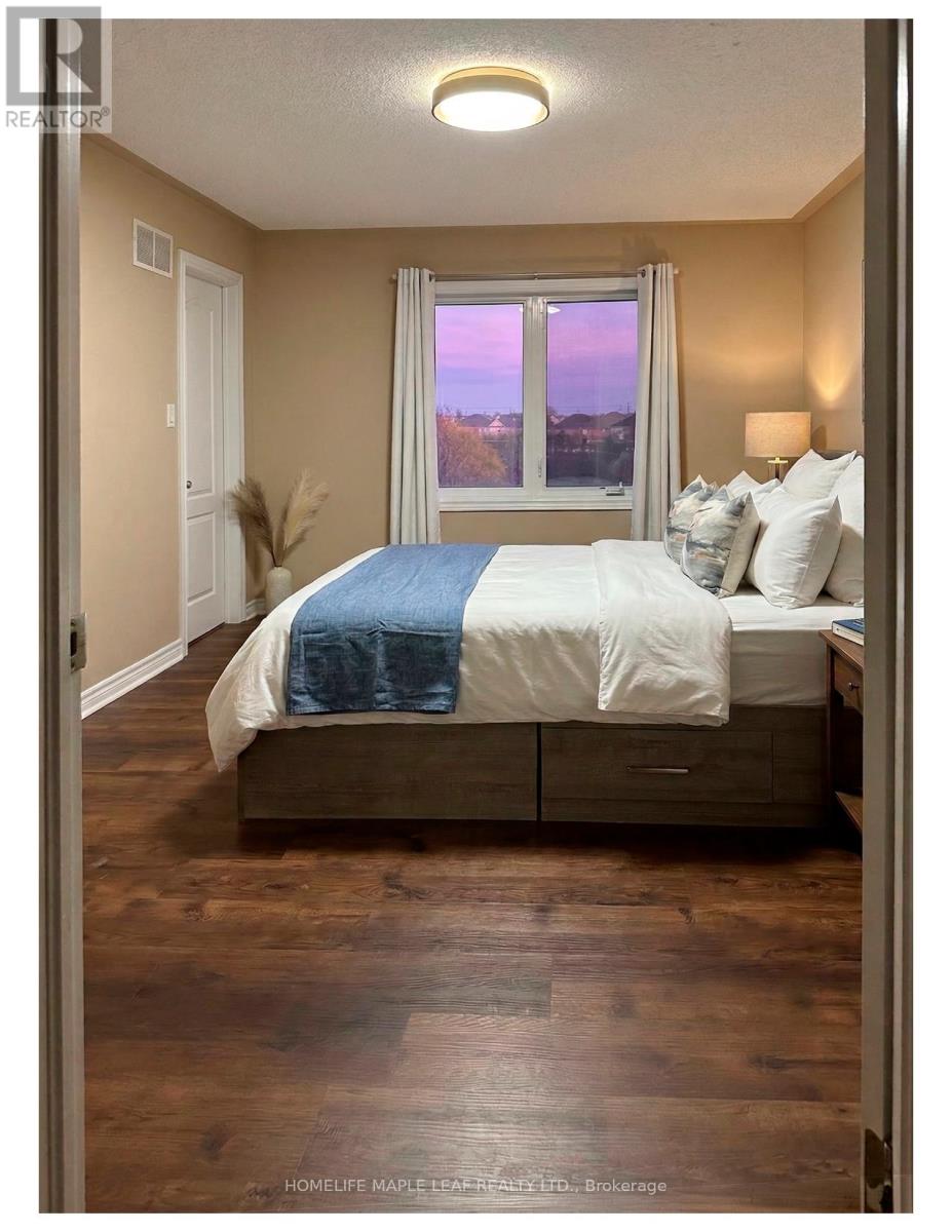A bedroom with a bed, nightstand, and window.