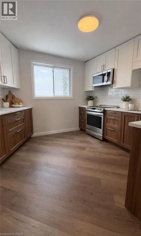 A kitchen with wooden cabinets and a stove top oven.