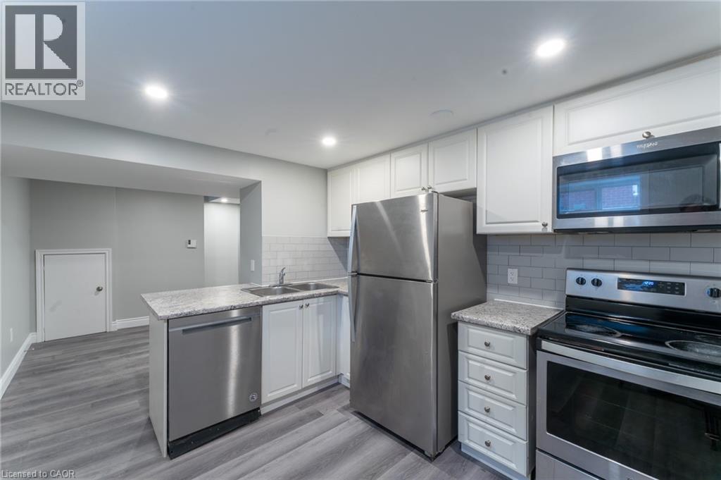 A kitchen with stainless steel appliances and white cabinets.