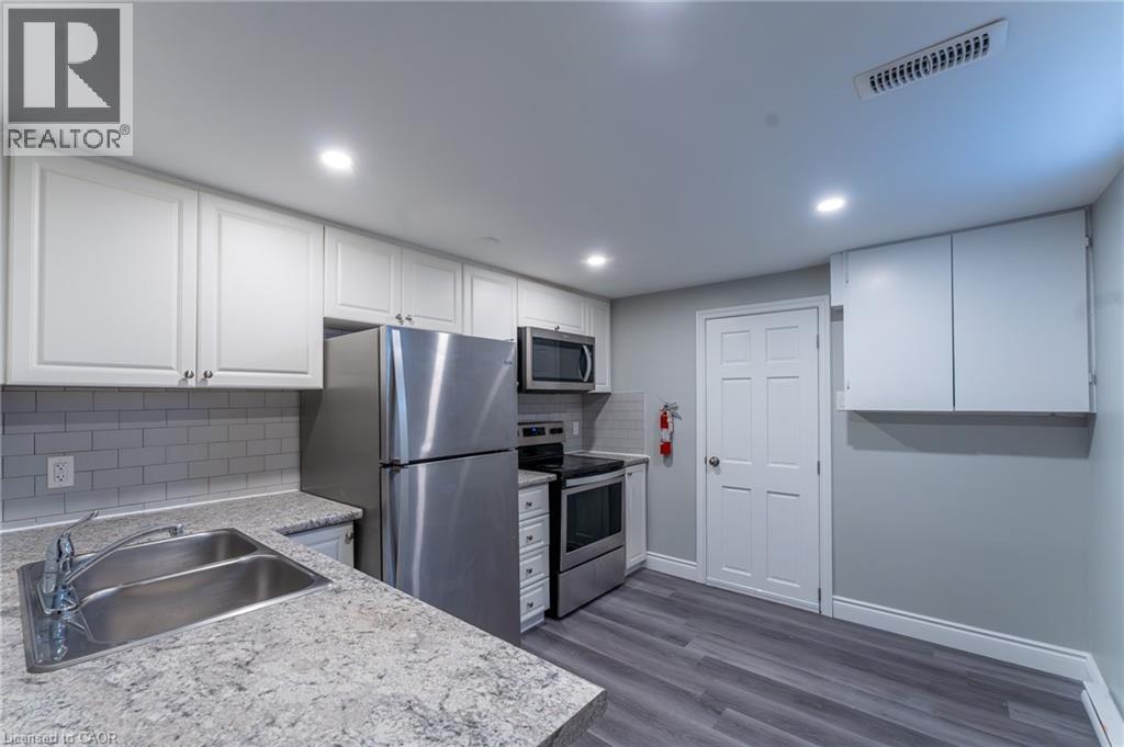 A kitchen with a sink, stove, and refrigerator.